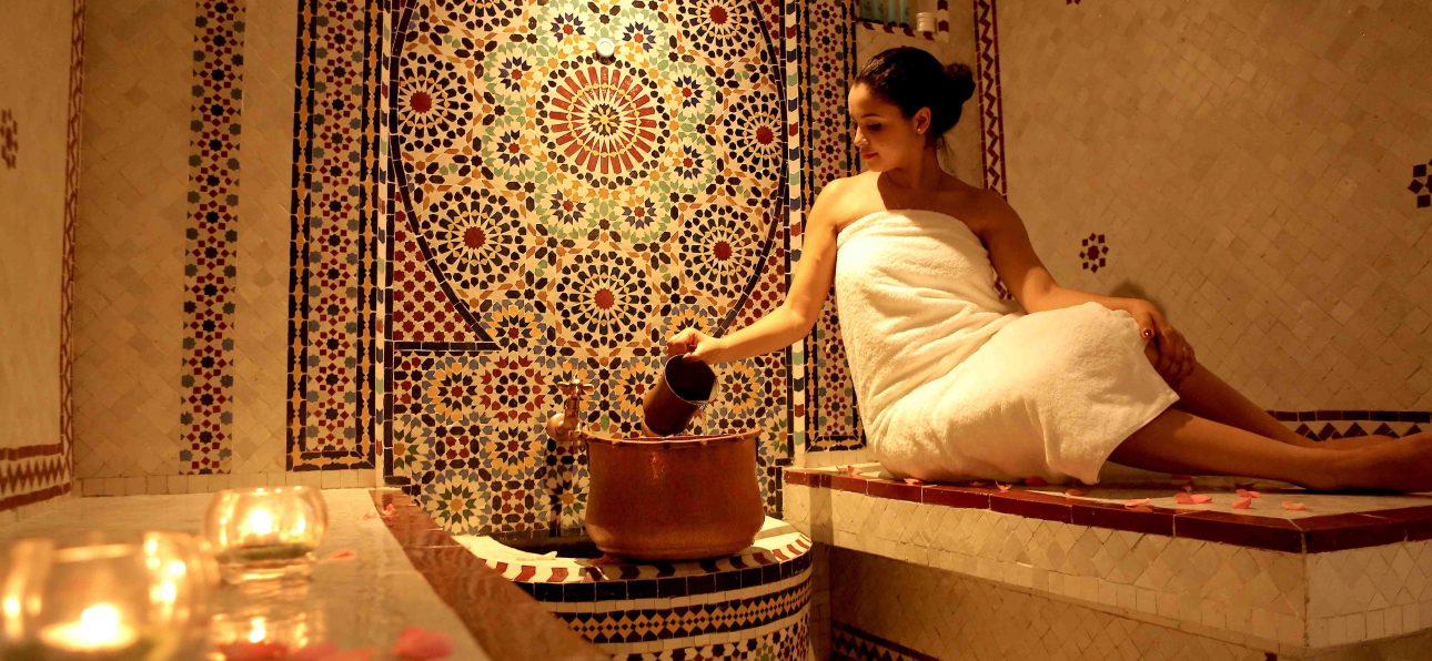 A woman enjoying a luxurious Moroccan hammam spa experience with handmade products