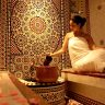 A woman enjoying a luxurious Moroccan hammam spa experience with handmade products