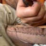 Skilled artisan handcrafting a Moroccan leather bag with traditional designs