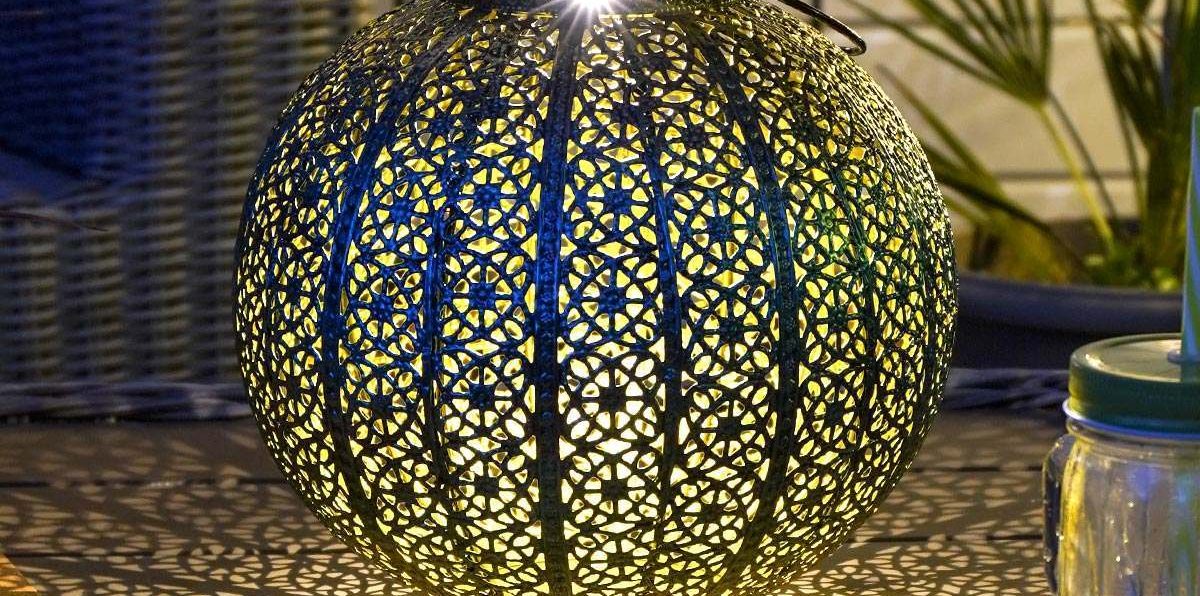 Moroccan Brass Lantern Casting Warm Glow in Outdoor Garden