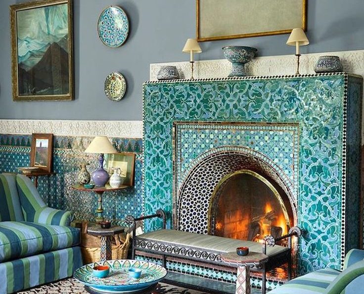 A beautifully decorated Moroccan-inspired living room with leather pouffs and vibrant patterns.