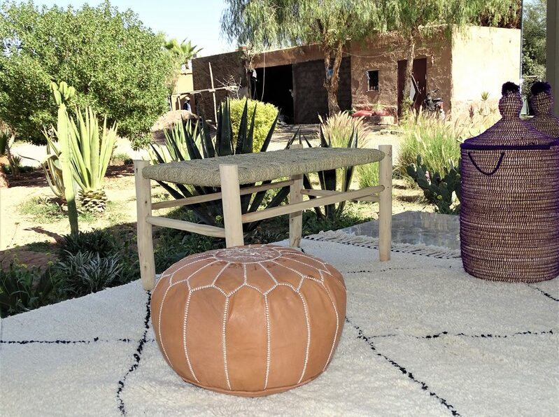 Moroccan handmade pouffs displayed in a lush garden setting